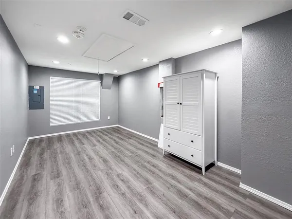an empty room with cabinet and wooden floors