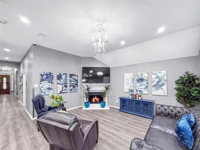 a living room with furniture a fireplace and a chandelier