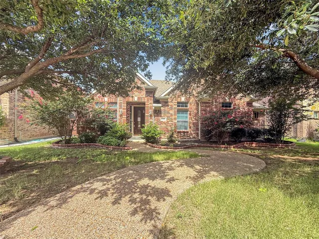 a view of a yard in front of a house with large trees