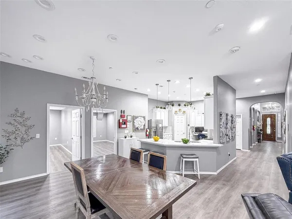 a view of a dining room and livingroom with furniture wooden floor a chandelier