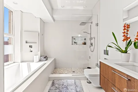 a bathroom with a granite countertop sink a toilet and shower