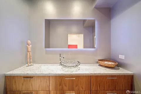 a bathroom with a granite countertop sink and a mirror