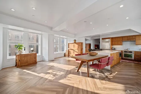 a living room with furniture a dining table and kitchen view with wooden floor