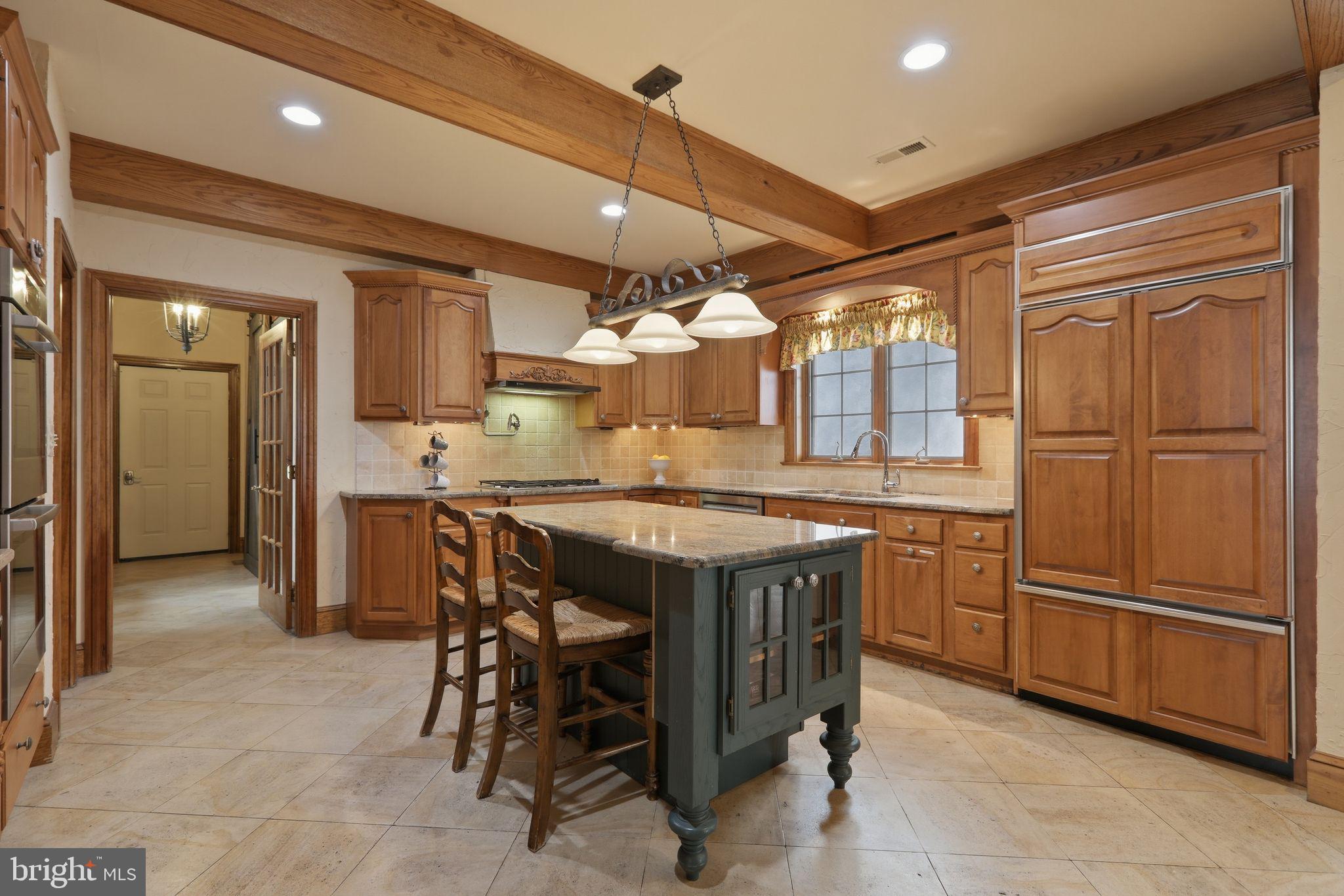 231 Hill Road Elverson, PA 19520 - Photo 15 of 60 a kitchen with granite countertop a table chairs stainless steel appliances and cabinets