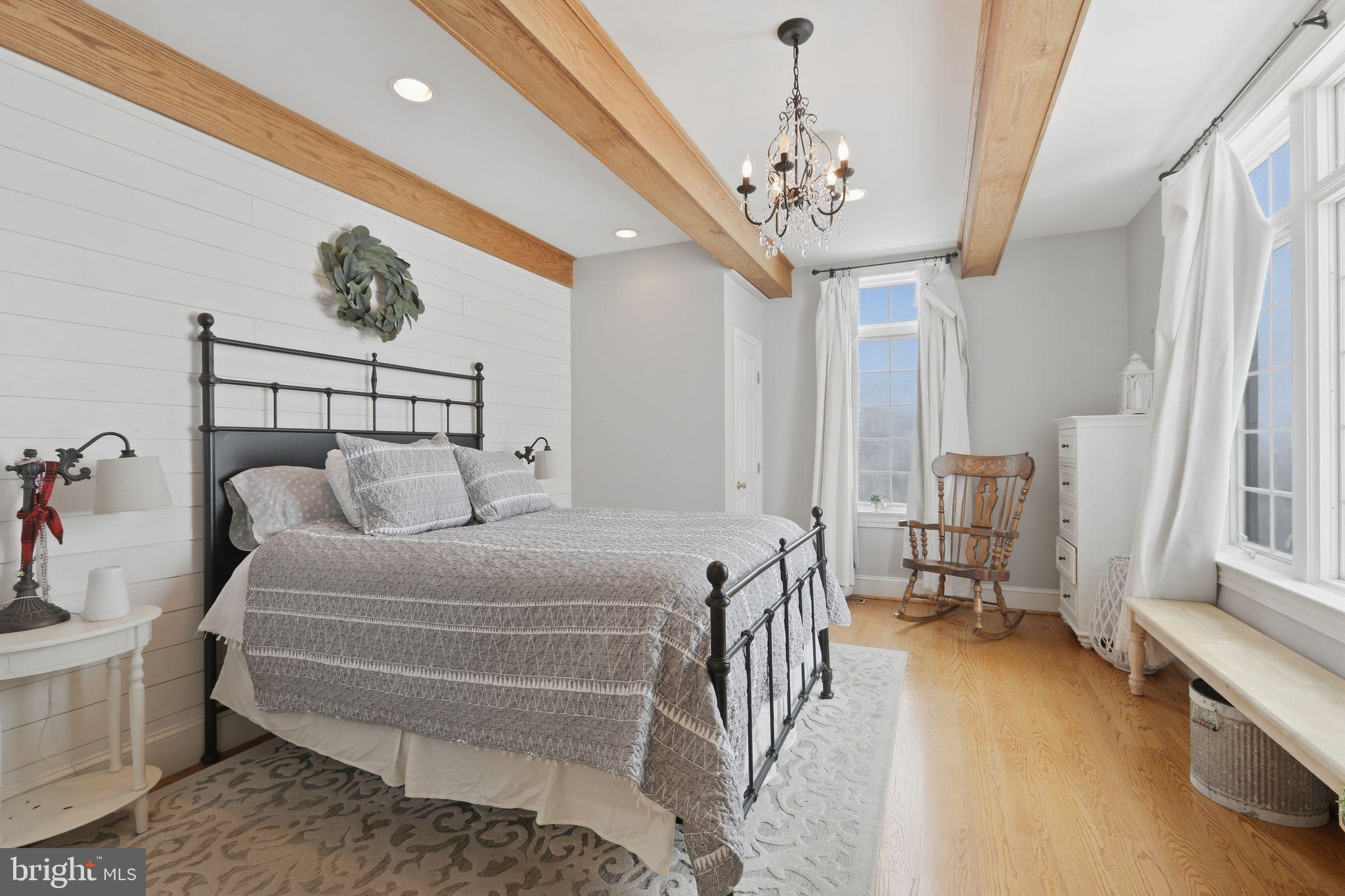 231 Hill Road Elverson, PA 19520 - Photo 26 of 60 a spacious bedroom with a bed and a chandelier