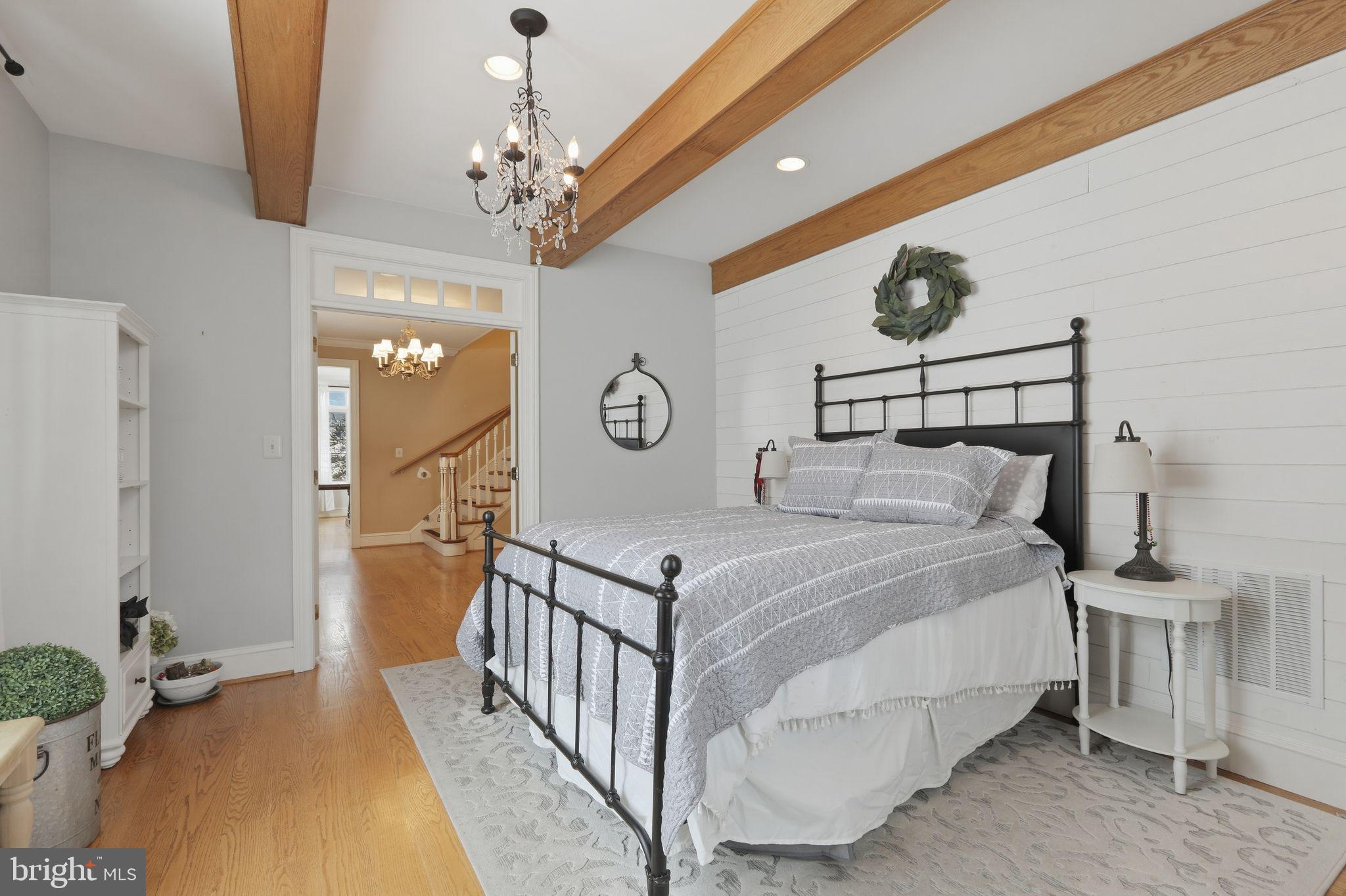 231 Hill Road Elverson, PA 19520 - Photo 27 of 60 a bedroom with a bed and a chandelier