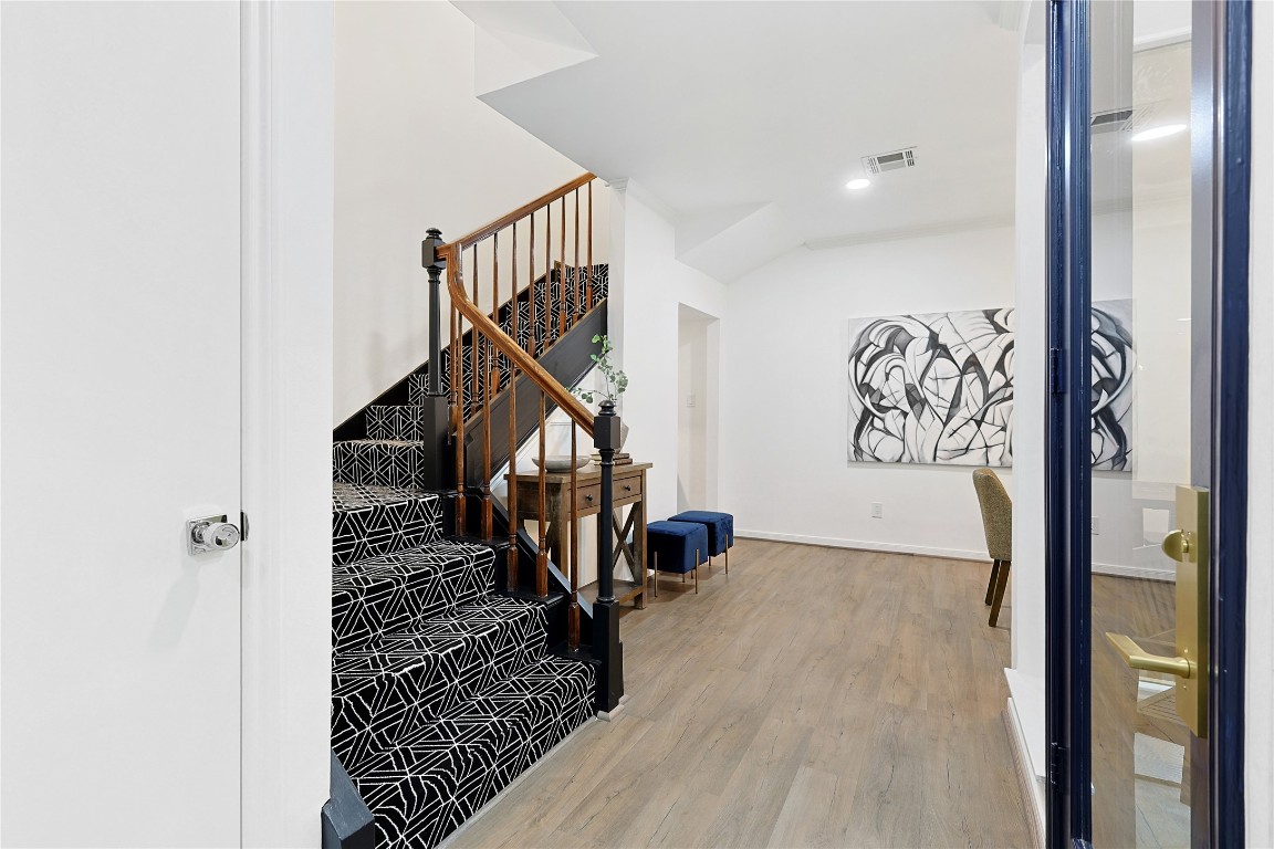 526 Colquitt Street Houston, TX 77006 - Photo 13 of 30 The statement staircase features a bold patterned carpeting and wooden railing.