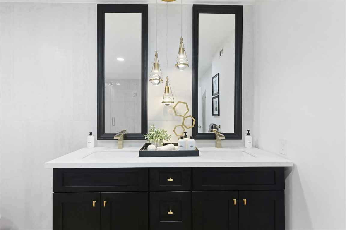 526 Colquitt Street Houston, TX 77006 - Photo 19 of 30 The main bathroom double vanity with twin mirrors and pendant lights add elegance, while decorative accents enhance the contemporary design.