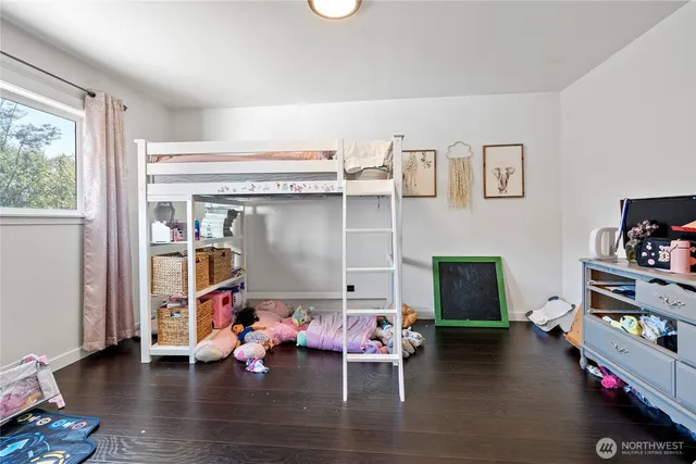 a open kitchen with stainless steel appliances granite countertop a stove top oven a sink a dining table and chairs with wooden floor