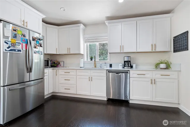 a kitchen with stainless steel appliances a refrigerator sink and cabinets