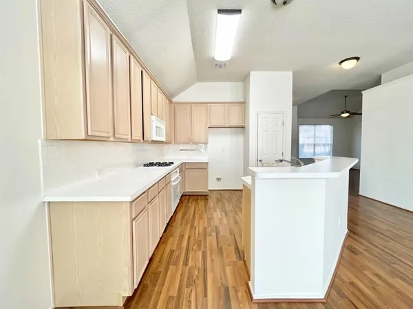 a kitchen with sink a refrigerator and wooden cabinets