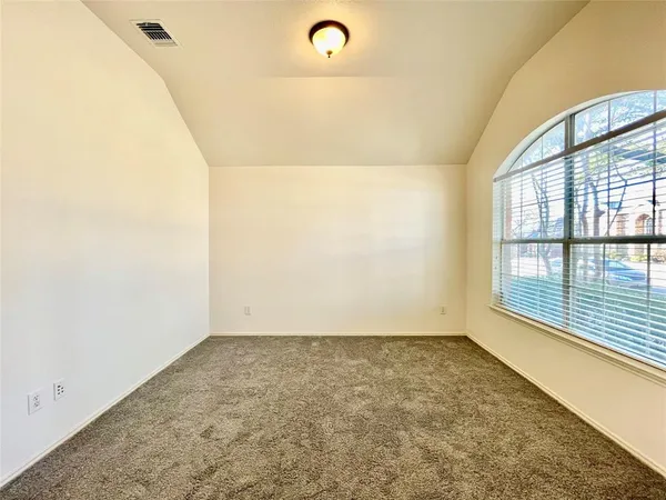 en empty room with ceiling fan and window