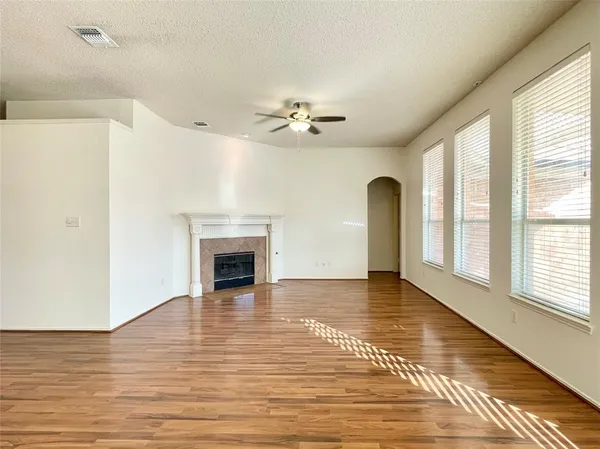 a view of empty room with a fireplace and wooden floor