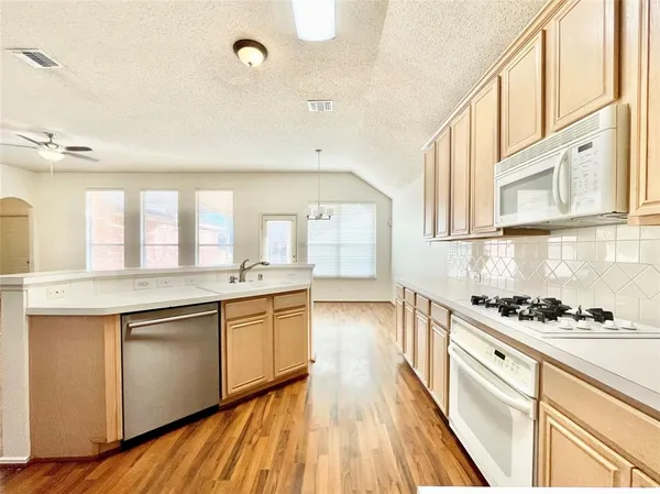 a large kitchen with stainless steel appliances granite countertop a stove and a sink