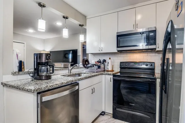 a kitchen with granite countertop a stove sink and microwave