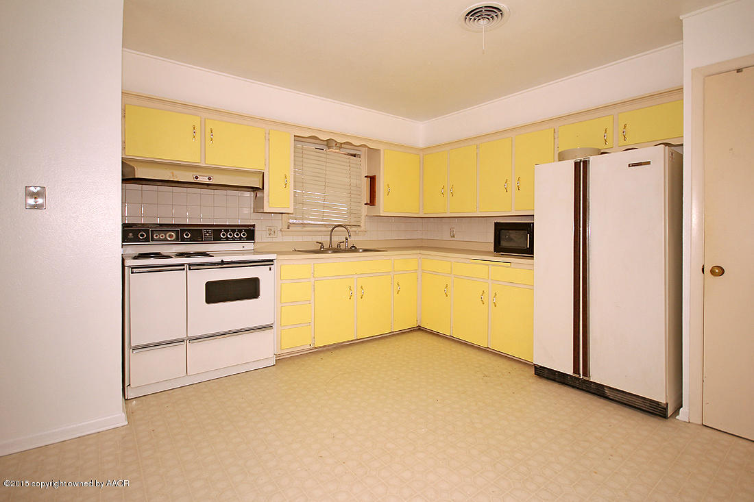 4313 South Bonham Street Amarillo, TX 79110 - Photo 8 of 21 a kitchen with stainless steel appliances a stove a microwave a sink and white cabinets