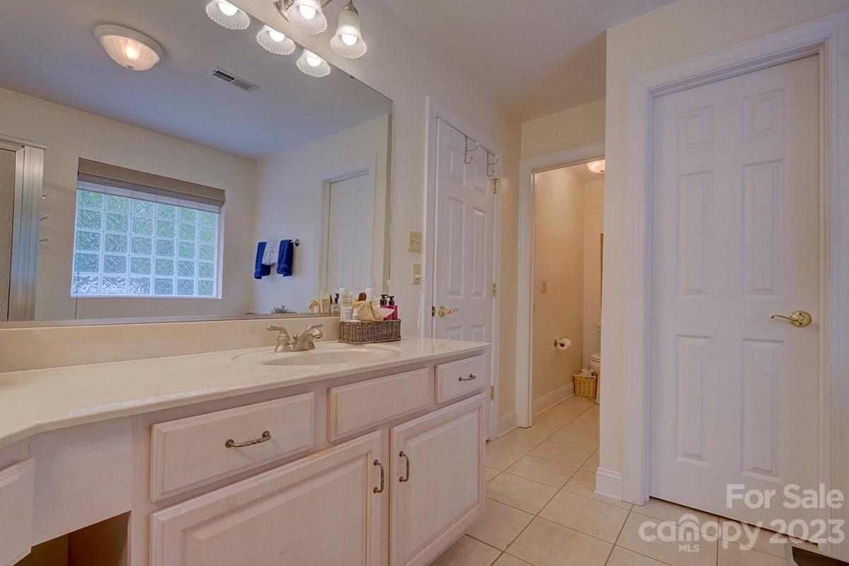 1129 Blowing Rock Cove Fort Mill, SC 29708 - Photo 19 of 37 a spacious bathroom with a granite countertop sink a mirror and a bathtub