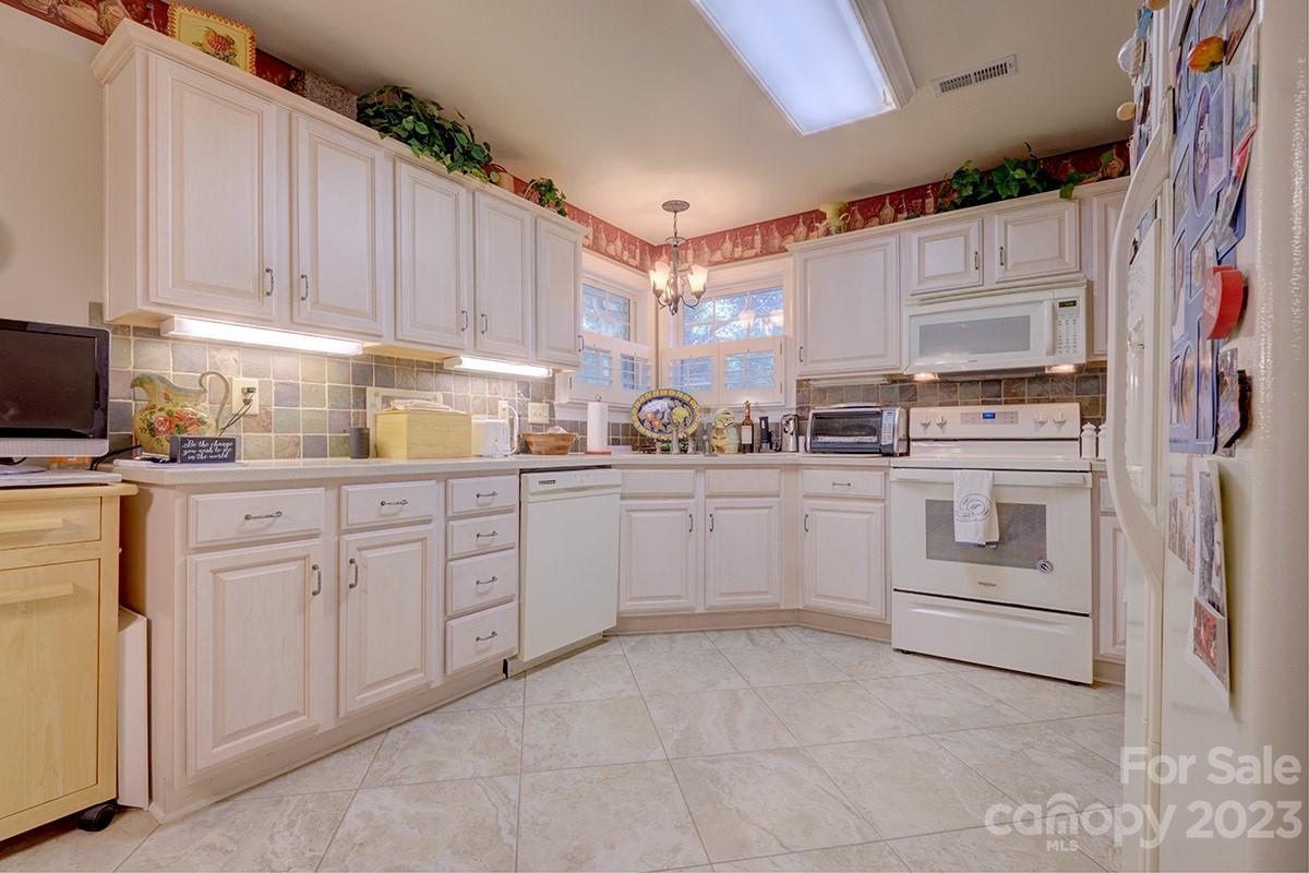 1129 Blowing Rock Cove Fort Mill, SC 29708 - Photo 9 of 37 a kitchen with white cabinets and white appliances