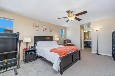 a spacious bedroom with a bed and a ceiling fan
