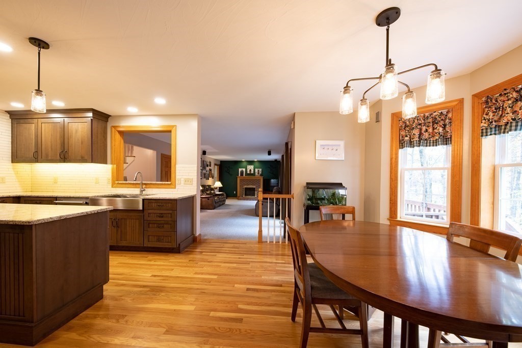 48 Easter Brook Road Lunenburg, MA 01462 - Photo 18 of 38 a kitchen with granite countertop a stove a sink a dining table and chairs