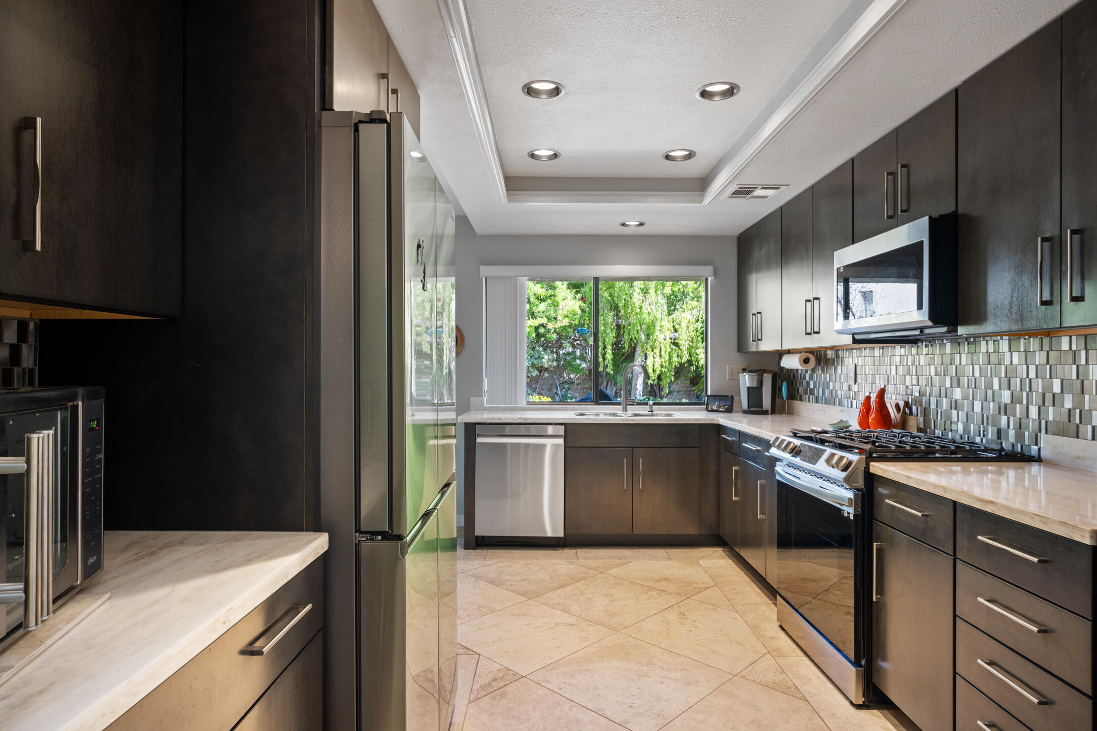 68640 Calle Mancha Cathedral City, CA 92234 - Photo 16 of 54 a kitchen with kitchen island granite countertop a stove sink and microwave