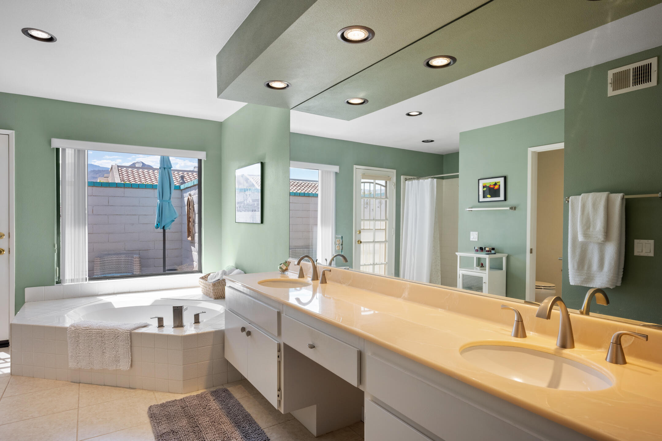 68640 Calle Mancha Cathedral City, CA 92234 - Photo 24 of 54 a bathroom with a granite countertop double vanity sink a bathtub and mirror