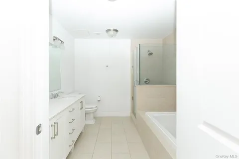 a bathroom with a granite countertop sink a toilet and shower