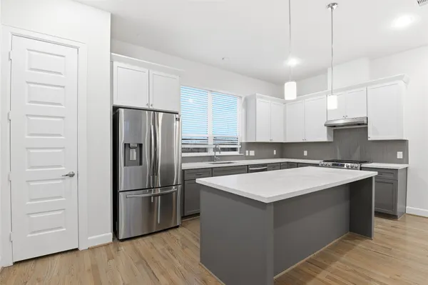 a kitchen with a refrigerator stove a sink and dishwasher with wooden floor