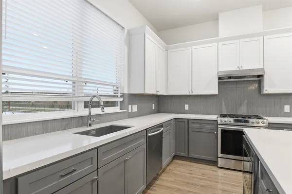 a kitchen with a sink stove and cabinets