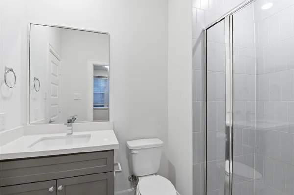 a bathroom with a sink a toilet and shower