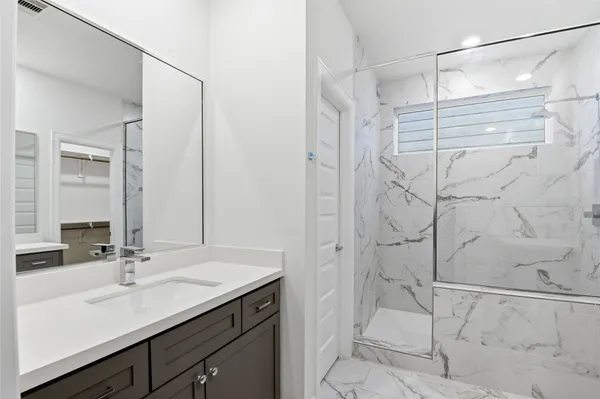 a bathroom with a shower and vanity sink