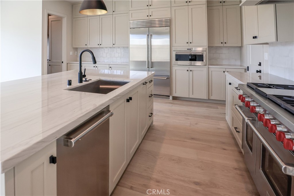 118 Mossvine Irvine, CA 92618 - Photo 4 of 31 a kitchen with white cabinets a sink and appliances