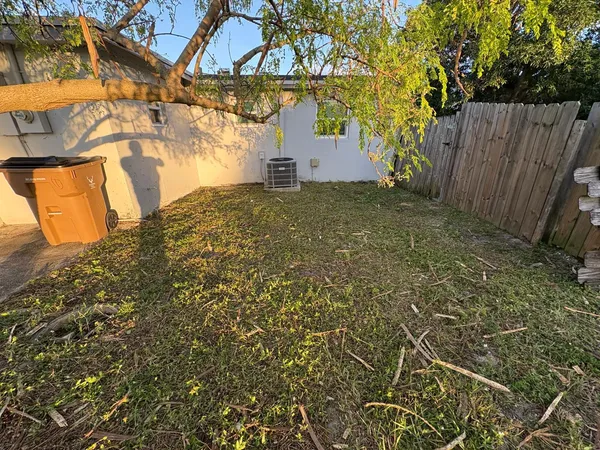 a view of a yard with wooden fence
