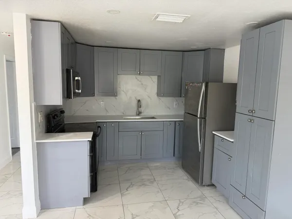 a kitchen with a refrigerator sink and cabinets