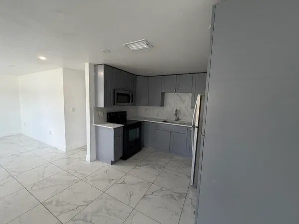 a kitchen with a sink a stove top oven and refrigerator