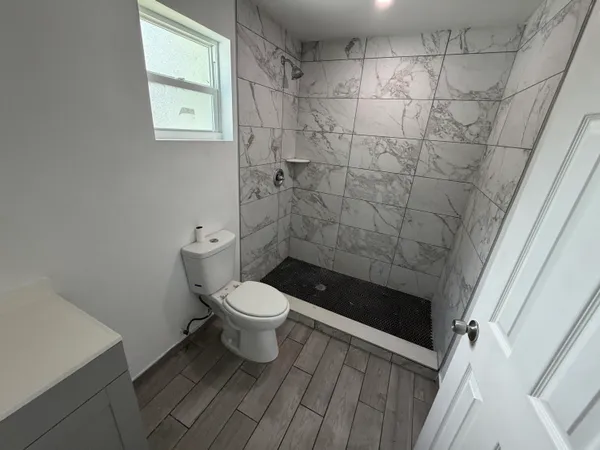 a bathroom with a toilet and a shower