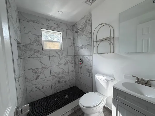 a bathroom with a toilet a sink and mirror