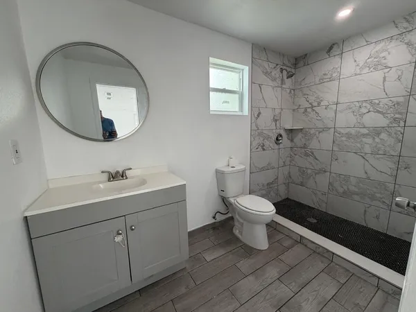 a bathroom with a toilet a sink and mirror