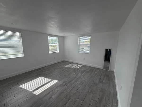 a view of wooden floor and windows in a room