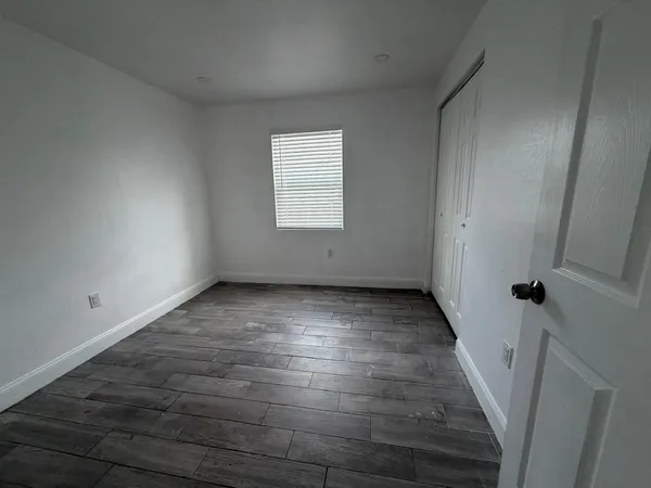 wooden floor in an empty room with a window