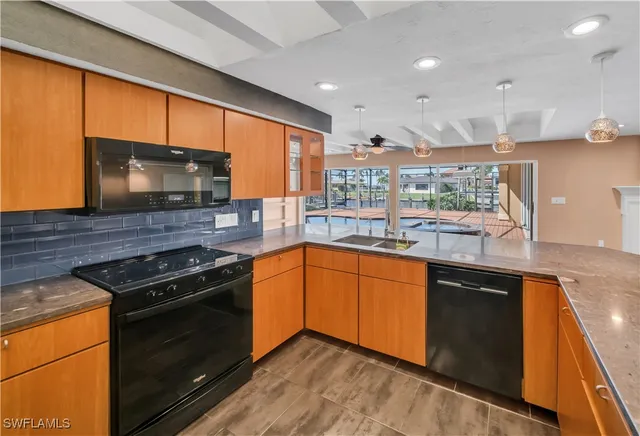 a kitchen with stainless steel appliances granite countertop wooden cabinets stove top oven and sink