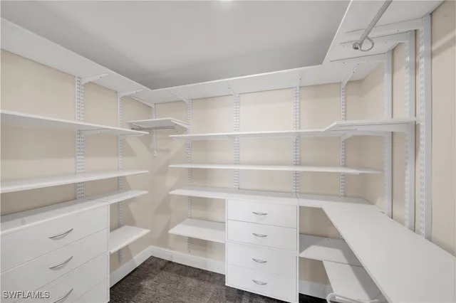 a view of walk in closet with empty racks