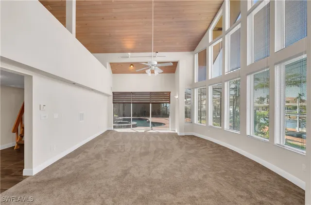 a view of an empty room with a fireplace and a window