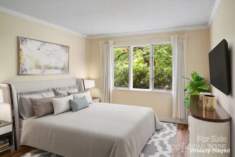 a bedroom with a bed a couch and a flat tv screen