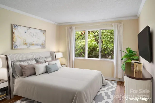 a bedroom with a bed a couch and a flat tv screen