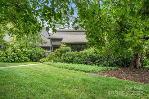 a view of a house with a yard and a tree