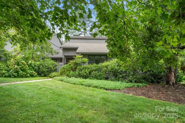 a view of a house with a yard and a tree
