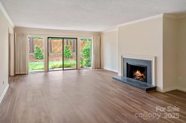 a view of an empty room with a fireplace and a window