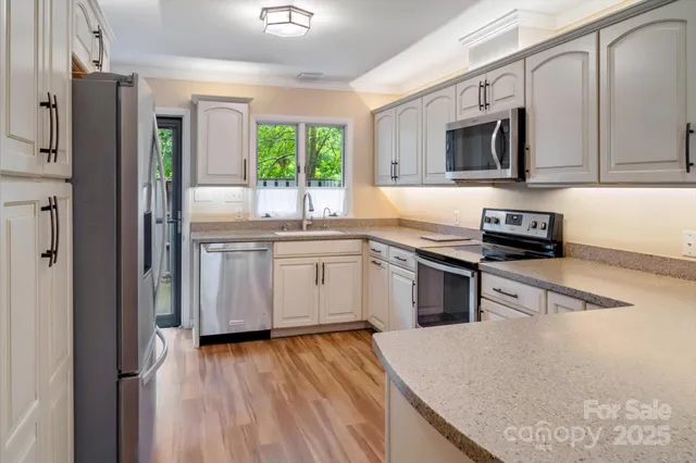 a kitchen with stainless steel appliances granite countertop a stove a sink and a microwave