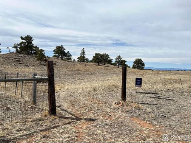 a view of a field with a building in the background